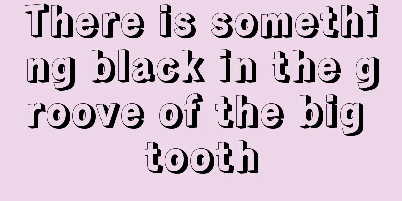 There is something black in the groove of the big tooth
